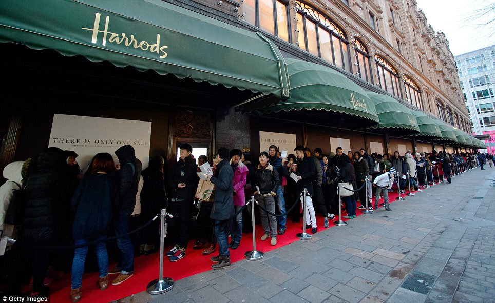 Getting ready: Shoppers queuing outside Harrods in Knightsbridge, where dozens of butlers are set to help customers