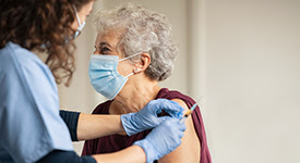 healthcare provider giving injection to elderly patient