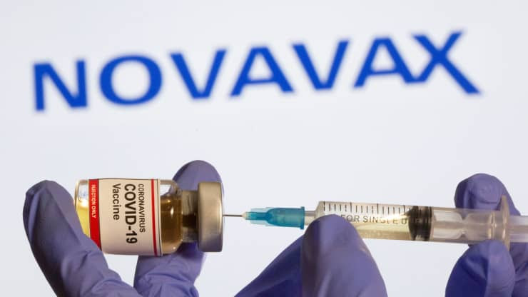 A doctors holds a a vial and a syringe of the Novavax vaccine