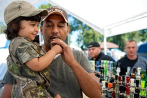 Man uses a duck call with help from toddler who he's holding