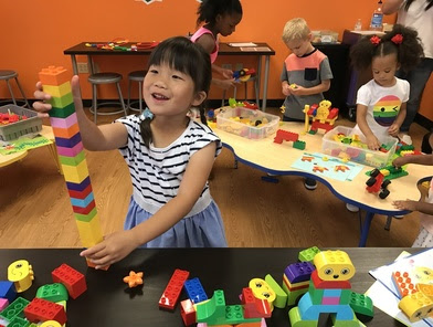 Young girl building LEGO tower