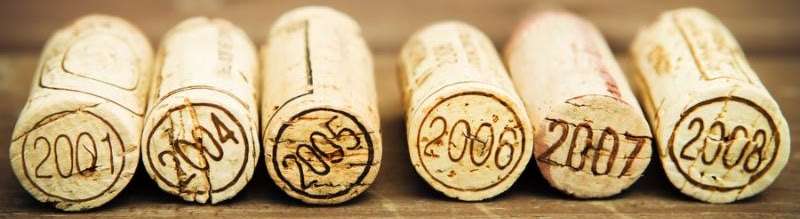 Dated wine bottle corks on the wooden background. Close up