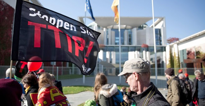 Los participantes en la manifestación contra el TTIP pasan por delante de la sede de la Cancillería, donde tiene su despacho Angela Merkel, en Berlín. EFE/EPA/JOERG CARSTENSEN