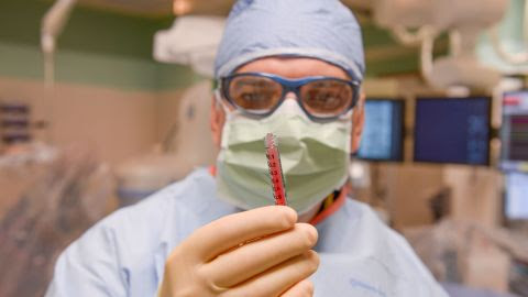 Dr. Emerson Perin holds up adult stem cells.