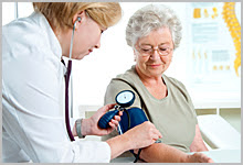 A woman getting her blood pressure taken by a nurse.