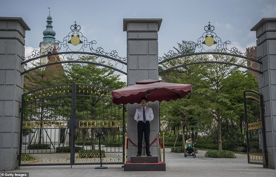 A Huawei security guard stands outside a gate of the Huawei complex. While the complex mainly functions as offices for Huawei workers, people can apply to visit some part of it as tourists