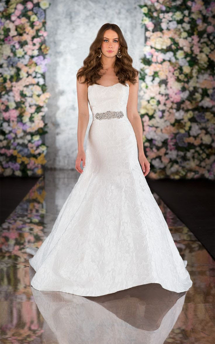 MARTINA LIANA - STYLE 563. For brides looking for figure flattering wedding dresses, Martina Liana introduces this fit-and-flare gown in Jacquard. An alluring shape that is sweetened with raised flower bursts, and a slightly scooped neckline, this designer wedding gown comes with the eye catching, hand-beaded Diamante Nora belt. Additional details include fabric-covered buttons and a traditional court train.