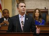 In this Jan. 8, 2020, file photo, Virginia Gov. Ralph Northam, center, gestures as he delivers his State of the Commonwealth address as House Speaker Eileen Filler-Corn, D-Fairfax, right, and Lt. Gov. Justin Fairfax, left, listen before a joint session of the Virginia Assembly at the state Capitol in Richmond, Va. (AP Photo/Steve Helber, File) ** FILE **