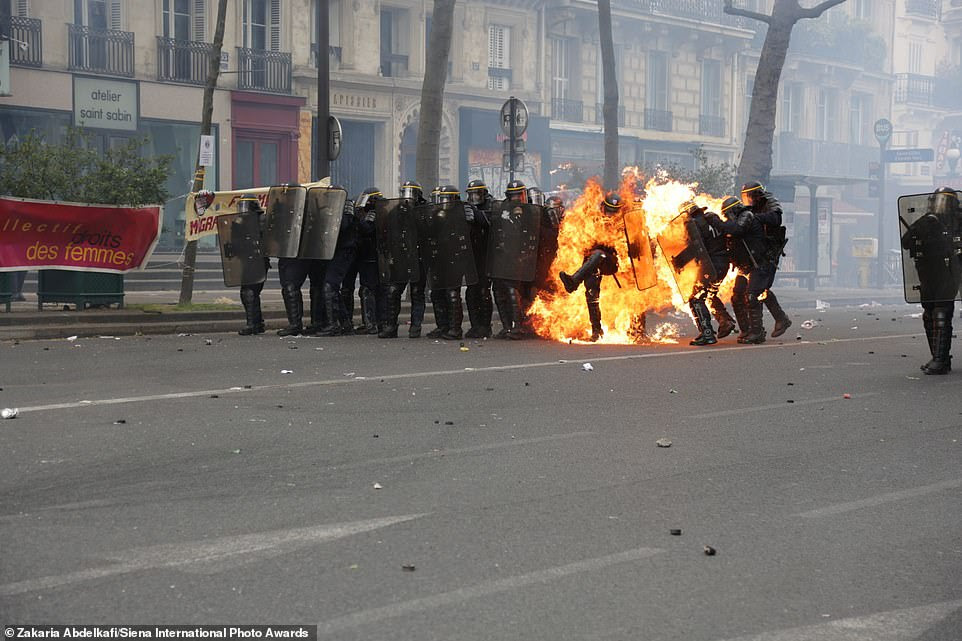 Photographer Zakaria Abdelkafi snapped this dramatic image of an anti-riot police officer engulfed in flames after being hit by a Molotov cocktail during violence in Paris. Mr Abdelkafi said he had no idea that the riot would end with the police officer being badly burned