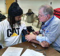 MRC volunteer takes patient's blood pressure