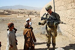 Australian Army Pvt. Levi Mooney, right, bumps fists with a child during a patrol in Tarin Kowt, Uruzgan province, Afghanistan, July 26, 2013 130726-Z-FS372-401.jpg