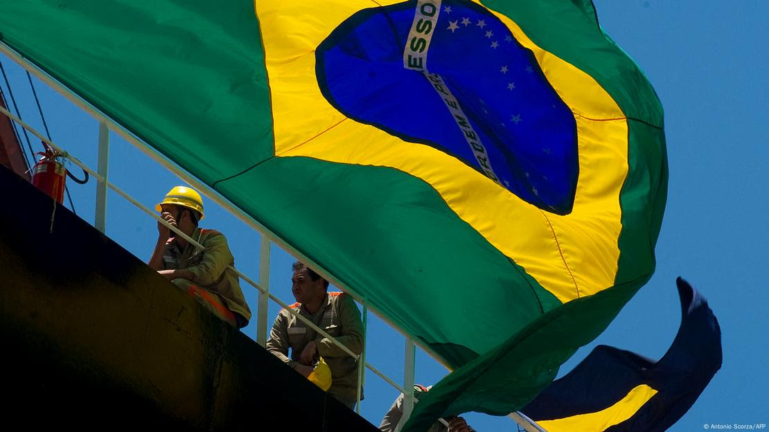 Bandeira do Brasil ao lado de trabalhadores da Petrobras