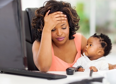 Woman at computer holding child