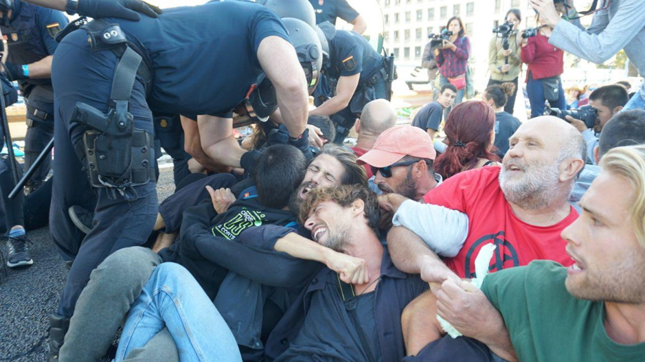 Rebels sat on the floor, linking their arms and bodies as police officers dressed in riot gear attempt to pull them away from the ground.