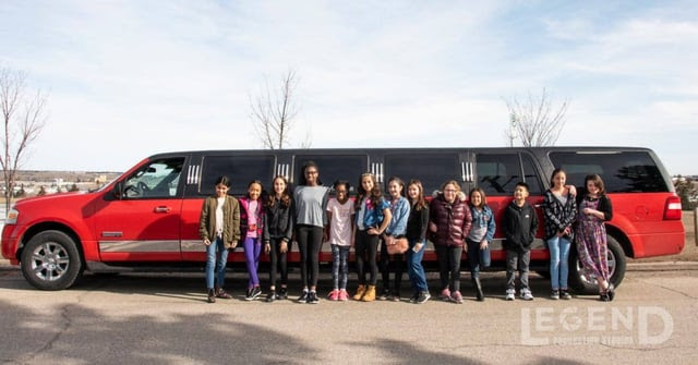 Kids celebrating birthday in front of red Expedition Stretch SUV Limo