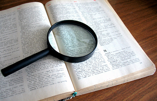 A magnifying glass on top of a book.