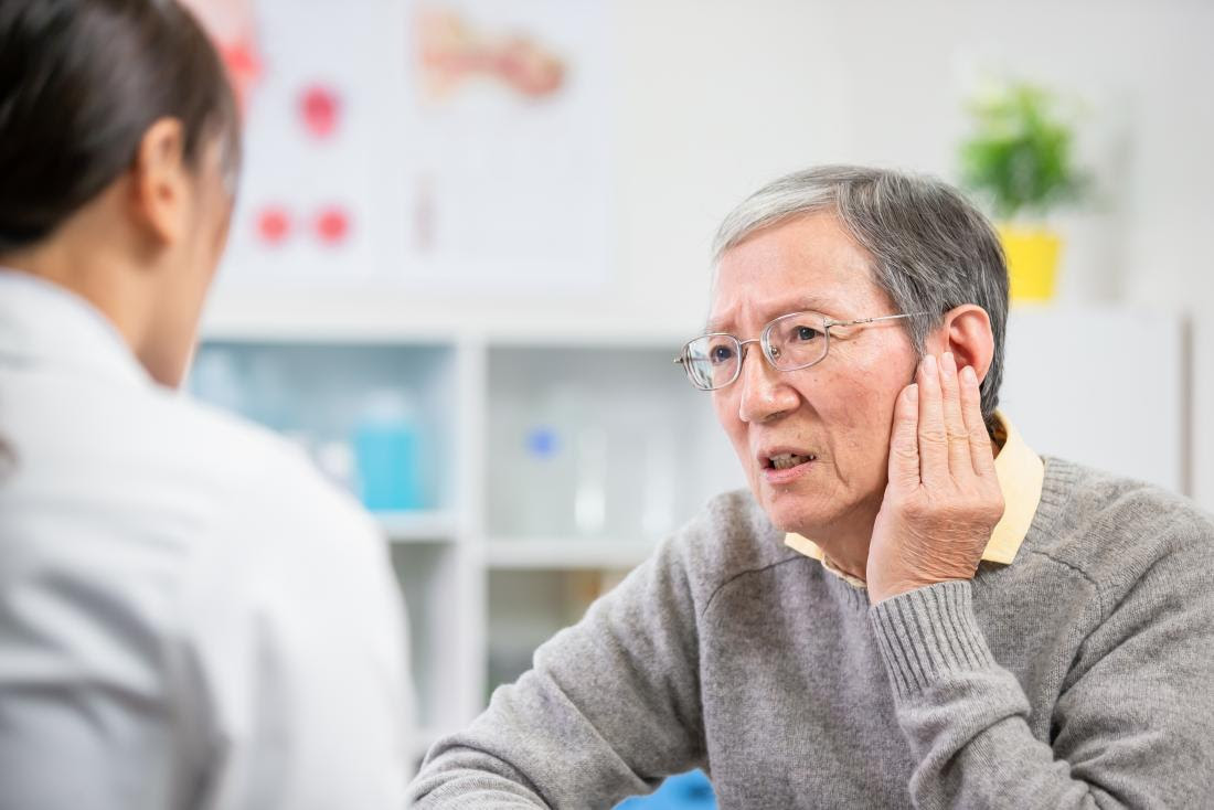 a man visiting the doctor because he is curious about the color of his earwax.