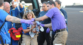 photo of healthcare responders carrying an injuried infant
