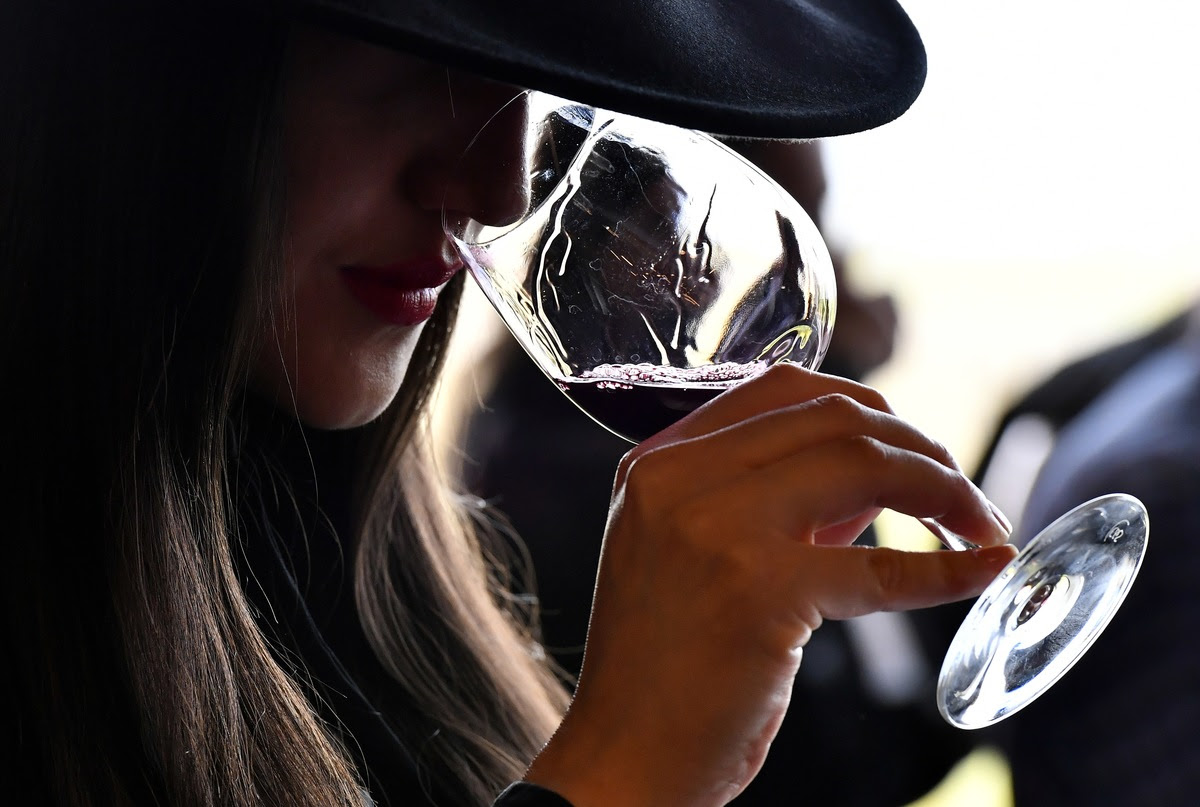 A woman tastes red wine during a wine tasting session at the Chateau La Dominique in Saint-Emilion