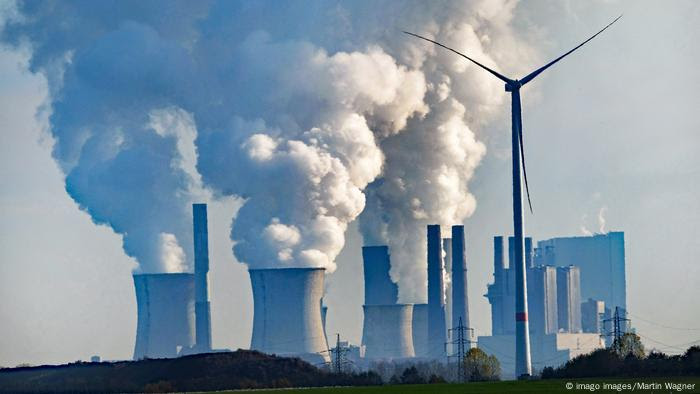 Chaminés de usina lançam grandes nuvens brancas de fumaça