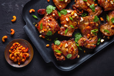 Grilled soy-basted chicken thighs with spicy cashews.