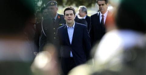 Greek Prime Minister Alexis Tsipras reviews an honor guard during his visit the Cyprus military cemetery on the outskirts of the capital Nicosia, Tuesday, Feb. 3, 2015. AP