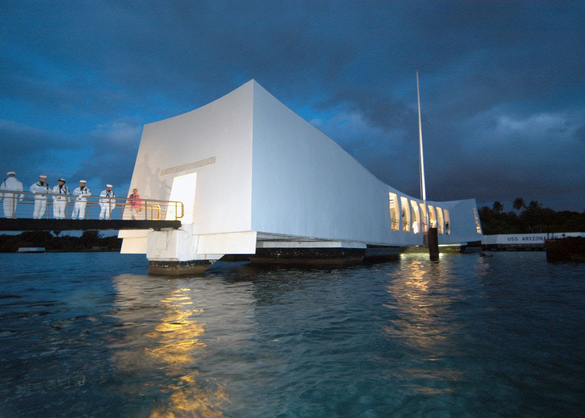 USS Arizona Memorial at dusk with a line of sailors on the dock assigned to the ceremonial guard