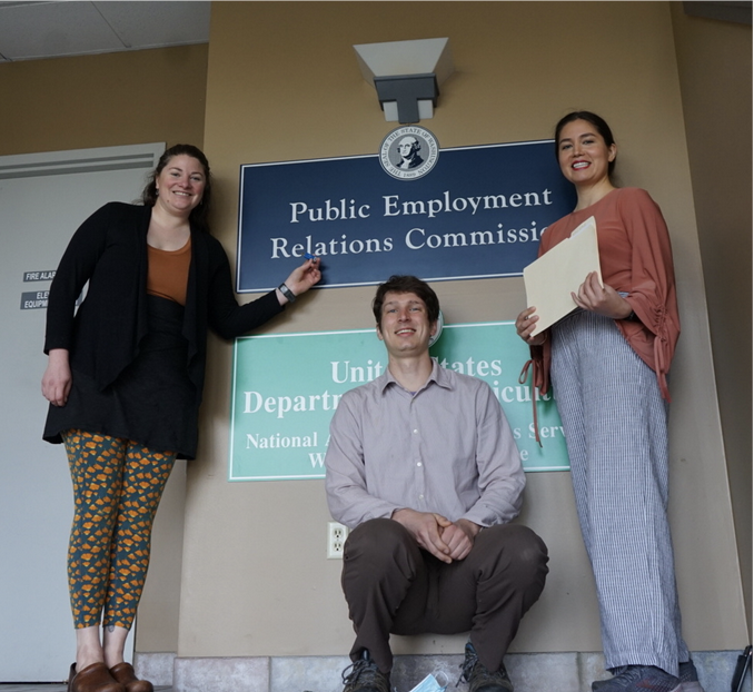 3 people standing in front of the Public Employment Relations Commission sign