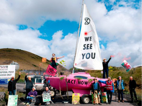 People on and around a pink boat, with the words We see you on the sail