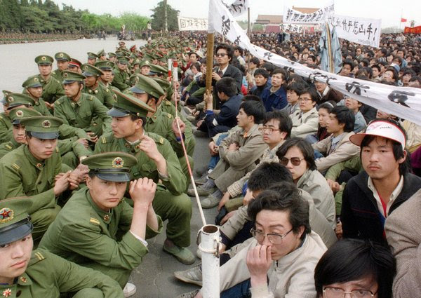 1989年4月在天安门广场，学生抗议者面对军警，哀悼前共产党领导人中的自由派胡耀邦的去世。