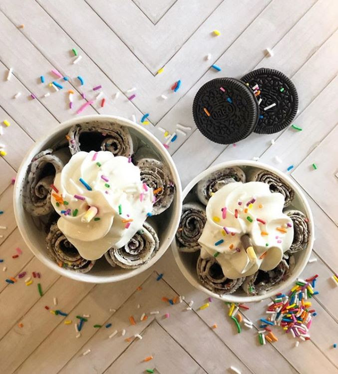 2 delloR Ice Cream cups with whipped cream and sprinkles on top