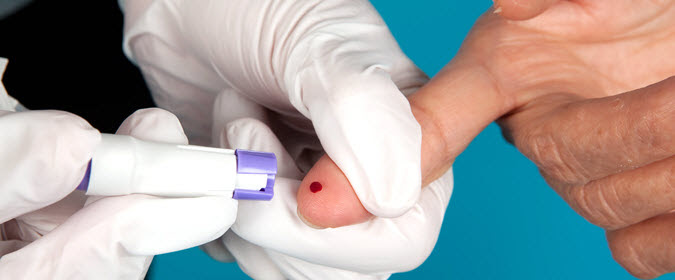 Health care provider does finger prick test on patient