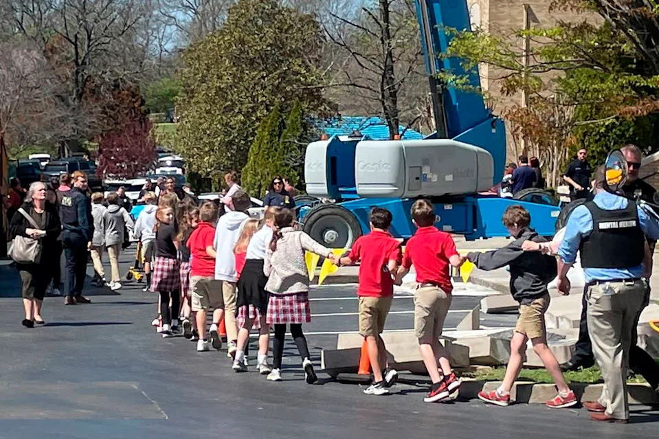 Children from The Covenant School, a private Christian school in Nashville, Tenn., hold hands as they are taken to a reunification site at the Woodmont Baptist Church after a shooting at their school, on Monday March, 27, 2023. (AP Photo/Jonathan Mattise)