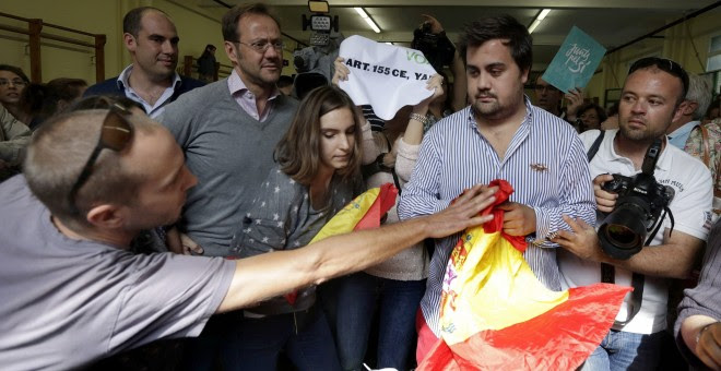 Un a persona trata de arrebatar una bandera a un miembro de VOX en el colegio donde acudió a votar en las elecciones que se celebran en Catalunya, el presidente de la Generalitat y número cuatro en las listas de Junt pel Si, Artur Mas, EFE/Alberto Estévez