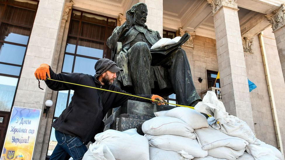 A museum worker takes measures to protect a statue in Zaporizhzhia – monuments such as these  are at risk of damage (Credit: Getty Images)