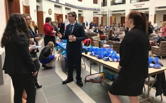 High school students congregate in the lobby of the University of Wyoming Business building dressed in professional attire during a break of their state conference for Future Business Leaders of America.