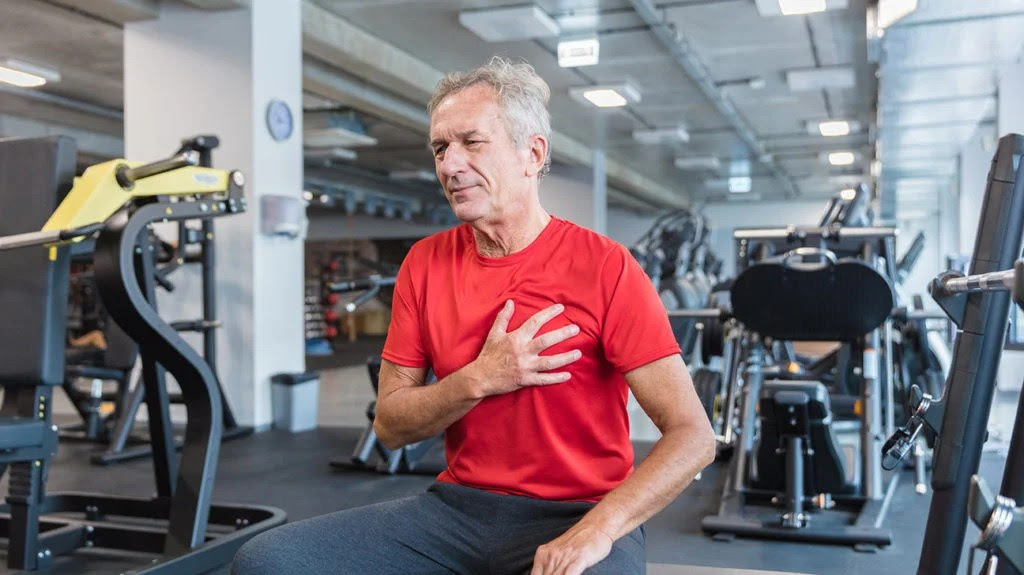 a man holding his chest in the gym due to a what is atrial flutter