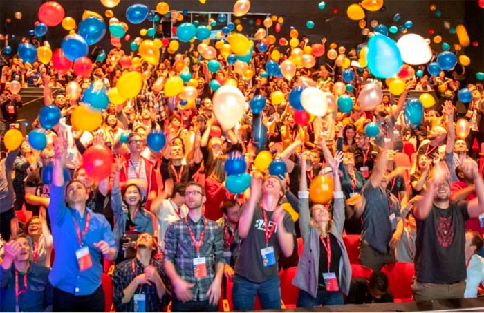 Photo of SmashingConf audience throwing balloons in the air