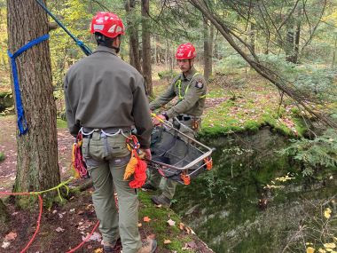Two Rangers at rope rescue training in the woods