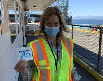 Photo of terminal employee holding up a 70th anniversary sticker