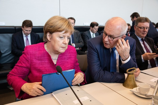 Germany's Chancellor Angela Merkel and the chairman of the Christian Democratic Union and Christian Social Union parliamentary group Volker Kauder attend a meeting Tuesday in Berlin.