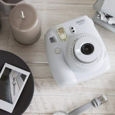 white Polaroid picture camera next to a picture