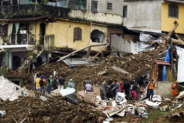 Tânia Rêgo/Agência Brasil Bombeiros, moradores e voluntários trabalham no local do deslizamento no Morro da Oficina, após a chuva que castigou Petrópolis, na região serrana fluminense