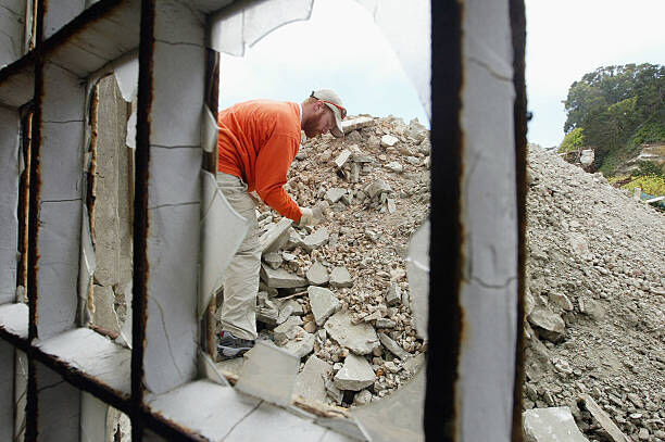 SAN FRANCISCO - JULY 2:  Volunteer rock breaker Kurt Flickinger picks rocks from a pile on Alcatraz Island July 2, 2003 in the San Francisco Bay, California. The park service, which manages Alcatraz as one of San Francisco