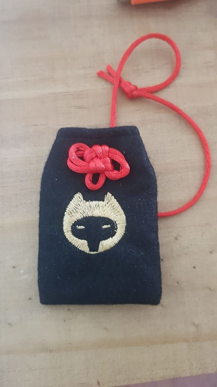 Samurai Doggy - uma história de vingança brutal 5 Saquinho de tecido com alça, e um bordado que representa uma cabeça de cachorro vista de frente.