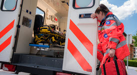 Stressed out paramedic leaning against ambulance