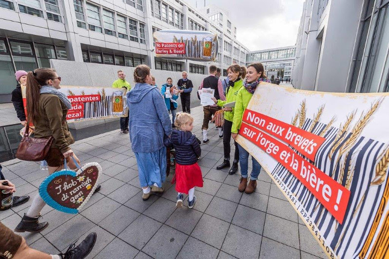 Les amateurs de bières se rendant à l’Oktoberfest passent par le siège de l’OEB. Ils y sont accueillis par des banderoles en 4 langues, appelant à s’opposer contre le brevet sur l’orge et la bière. Les amateurs de bières se rendant à l’Oktoberfest passent par le siège de l’OEB. Ils y sont accueillis par des banderoles en 4 langues, appelant à s’opposer contre le brevet sur l’orge et la bière.