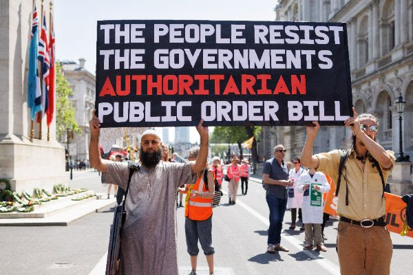 Two people hold a placard that reads The people resist the governments authoritarian public order bill