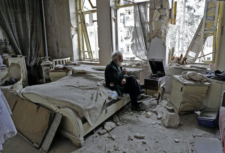 32 Sounds still, man sitting in destroyed room in Aleppo listening to record player