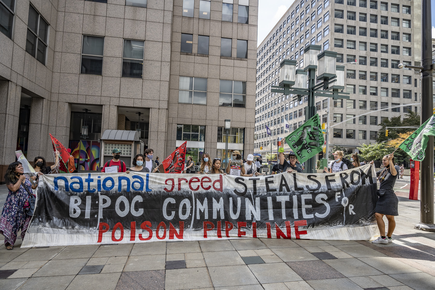 Photo: @kenschles. Protestors hold banner reading "National Greed steals from BIPOC communities for poison pipeline"